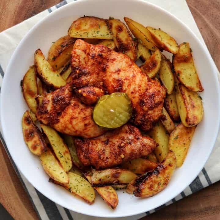 spicy chicken thighs and baked ranch potatoes in a white bowl