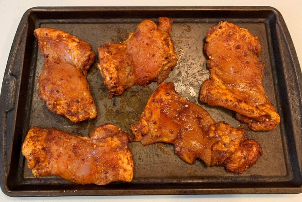 spicy chicken thighs on a baking sheet