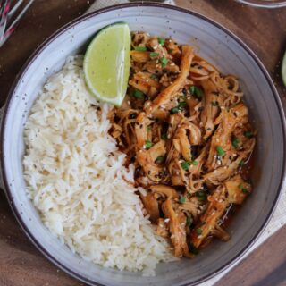 spicy coconut pulled chicken in a bowl with jasmine rice