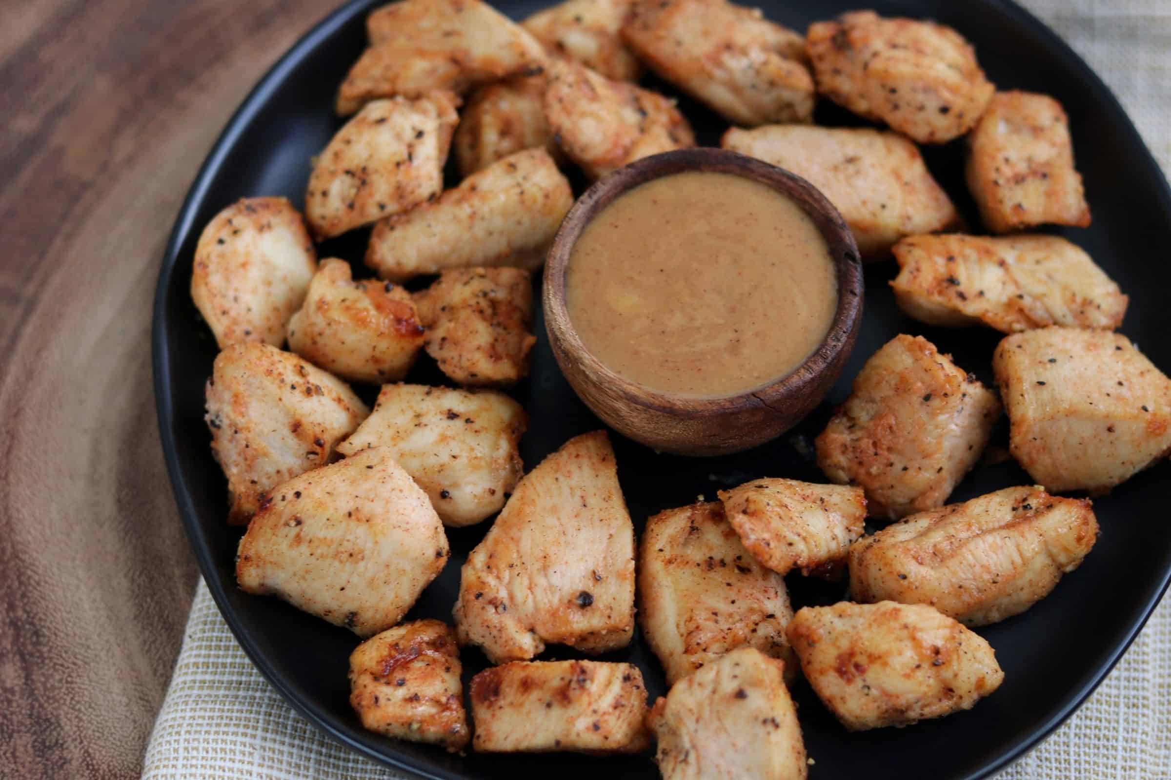 Chick-Fil-A grilled nuggets copycat on a black plate with honey bbq dipping sauce