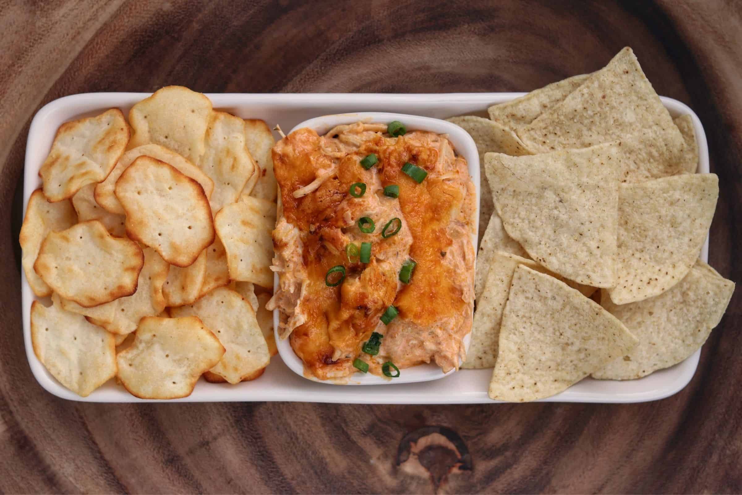 buffalo chicken dip in a bowl with chips and crackers