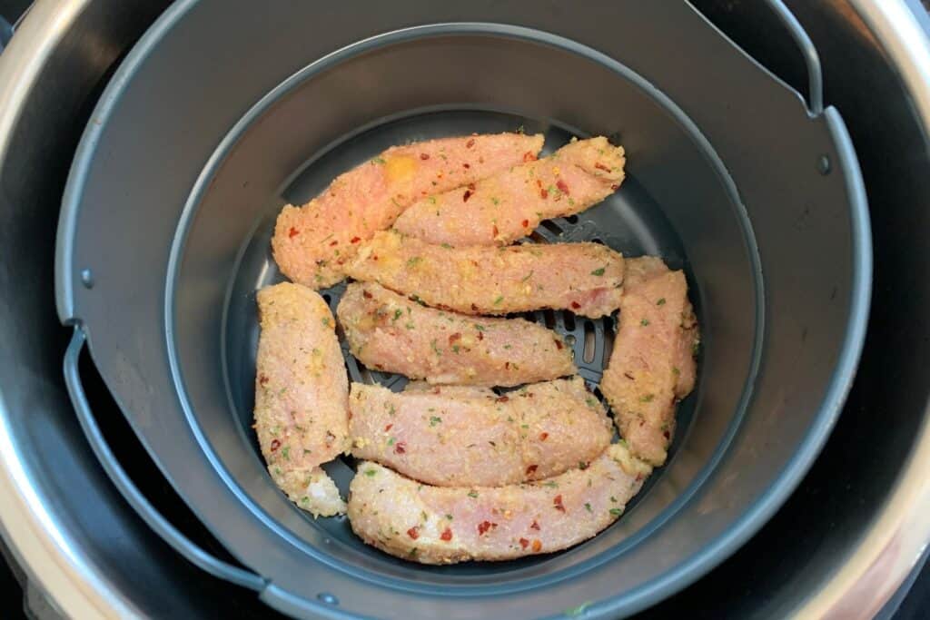seasoned chicken strips in the Instant Pot air fryer basket