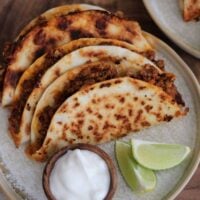 3 ground turkey tacos on a plate with fat free Greek yogurt and lime wedges