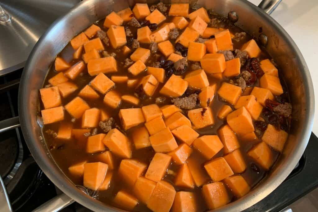 sweet potatoes and broth added to the skillet