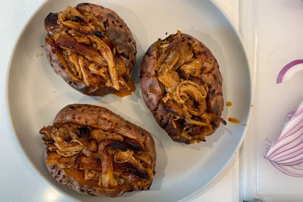 sweet potatoes cut open and filled with pulled BBQ chicken