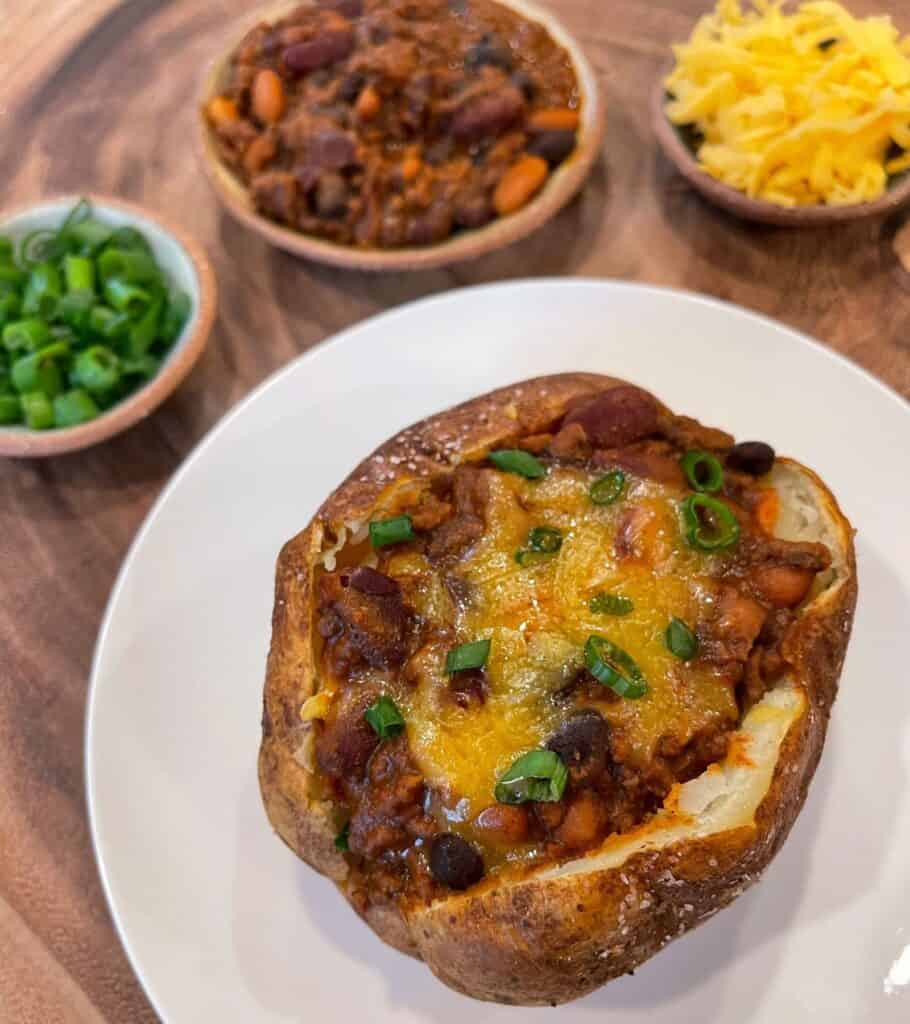 chili baked potato with cheddar cheese and scallions