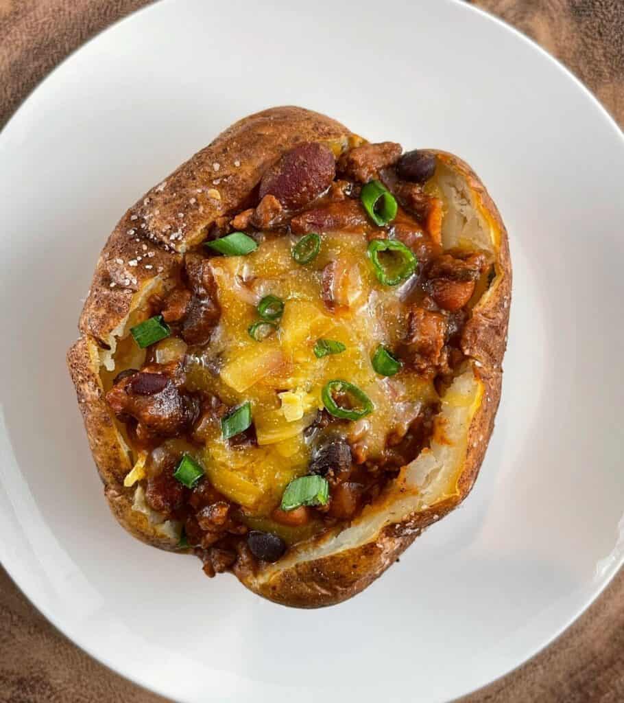 baked potato with high protein chili, cheddar cheese, and scallions