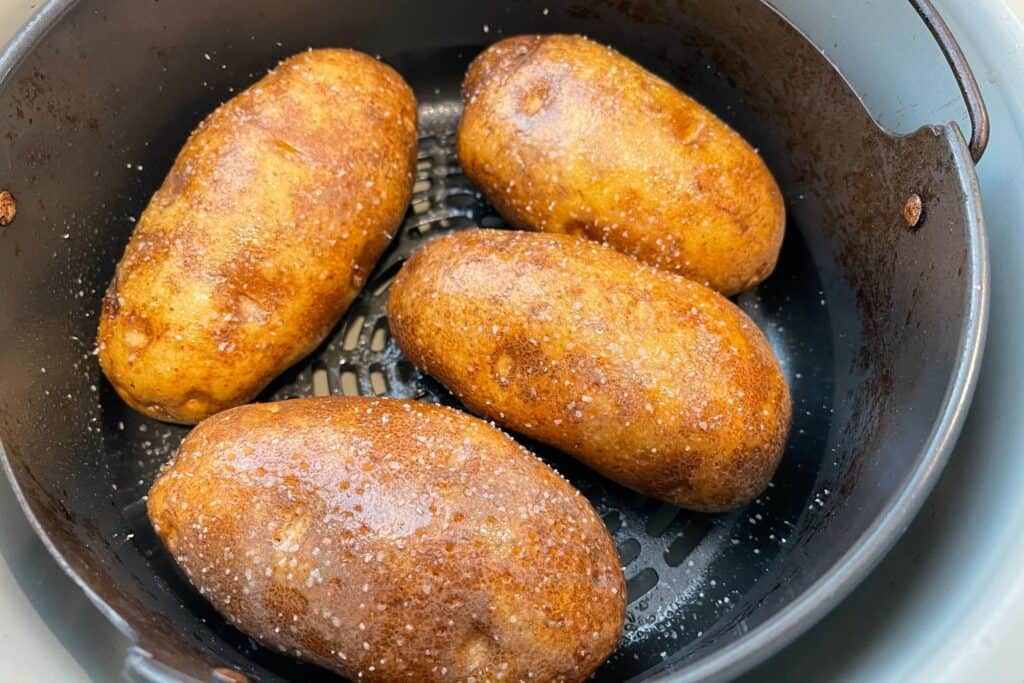 4 potatoes with cooking spray and salt in the ninja foodi air crisp basket