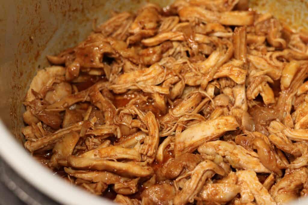 the shredded chicken back in the slow cooker with the sauce