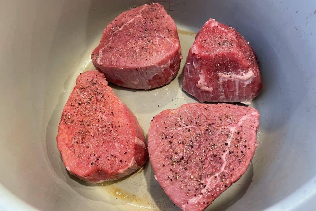 pieces of the beef with salt and pepper in the pressure cooker