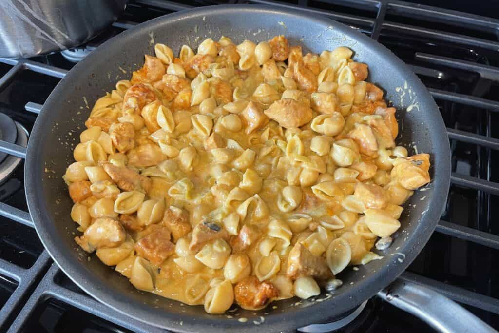 green chile mac and cheese in the skillet with the chicken