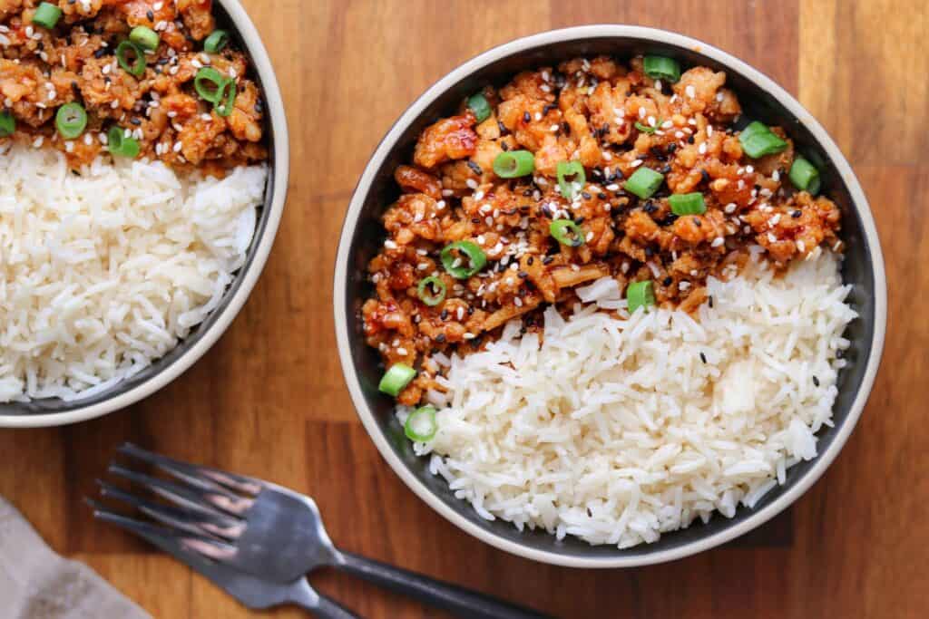 two bowls of firecracker ground chicken with rice