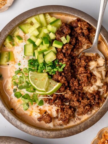 crispy ground beef and brothy rice bowls with cucumbers, scallions, and lime