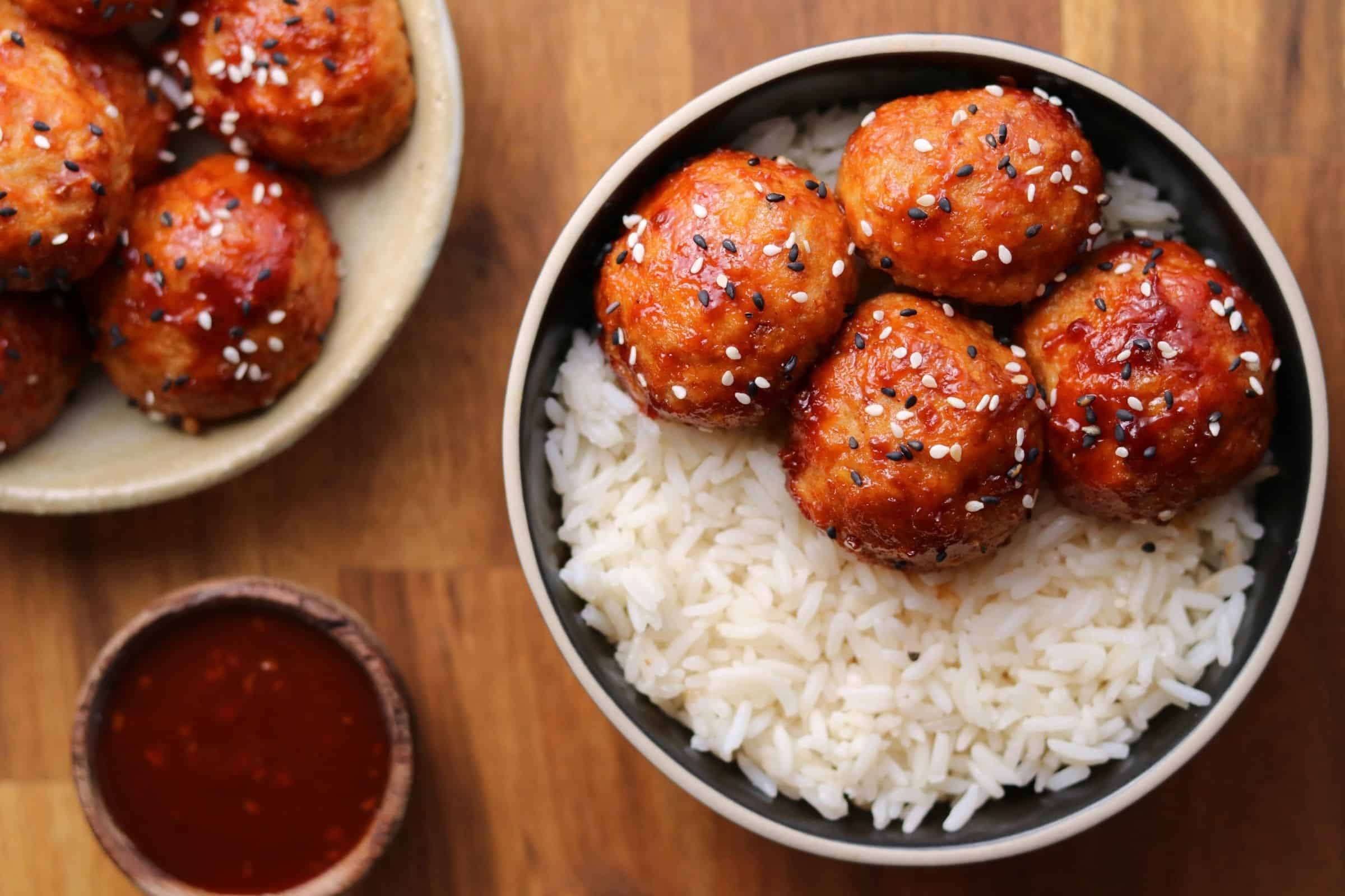 4 chicken meatballs in a bowl with rice