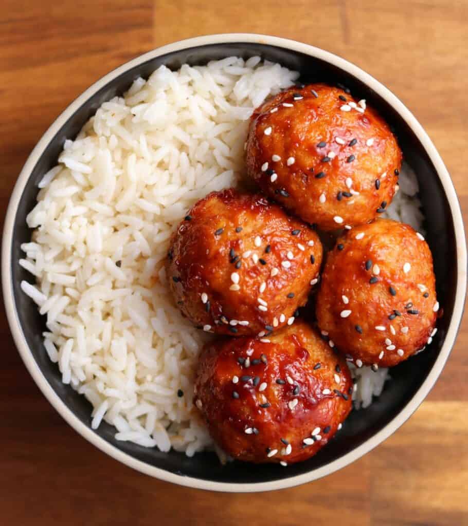 bbq chicken meatballs in a black bowl with white rice