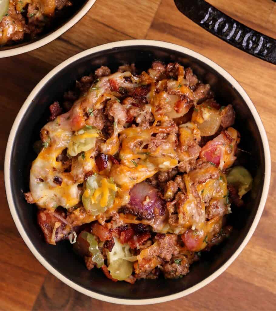 serving a portion of the cheeseburger skillet in a black bowl