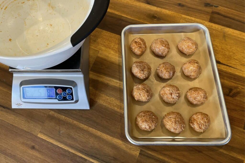 using a food scale to weigh out 12 50-gram chicken meatballs