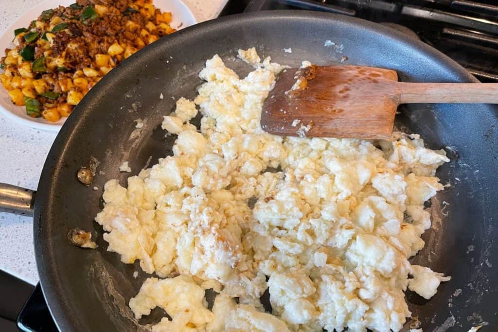 cooked egg whites in a skillet beside cooked chorizo and potato filling