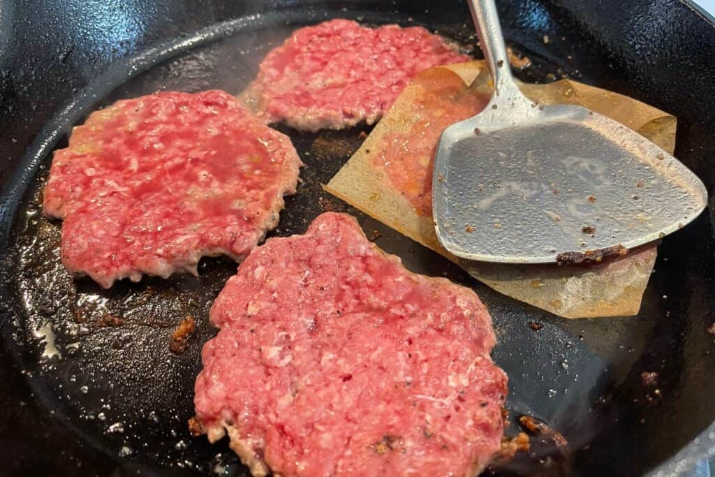 cooking smash burgers in a cast iron skillet