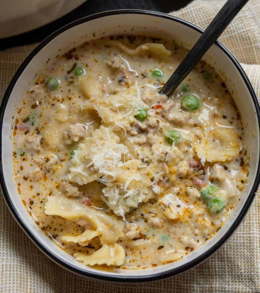 bowl of creamy chicken soup topped with grated parmigiano reggiano
