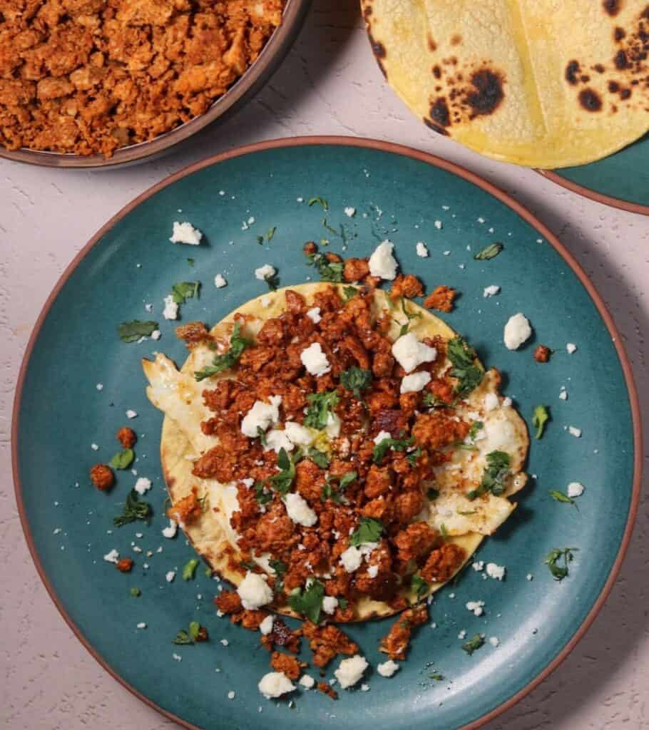 chorizo breakfast taco on a plate with cilantro and queso fresco
