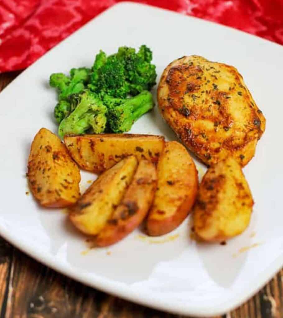 white plate with chicken, potatoes, and broccoli