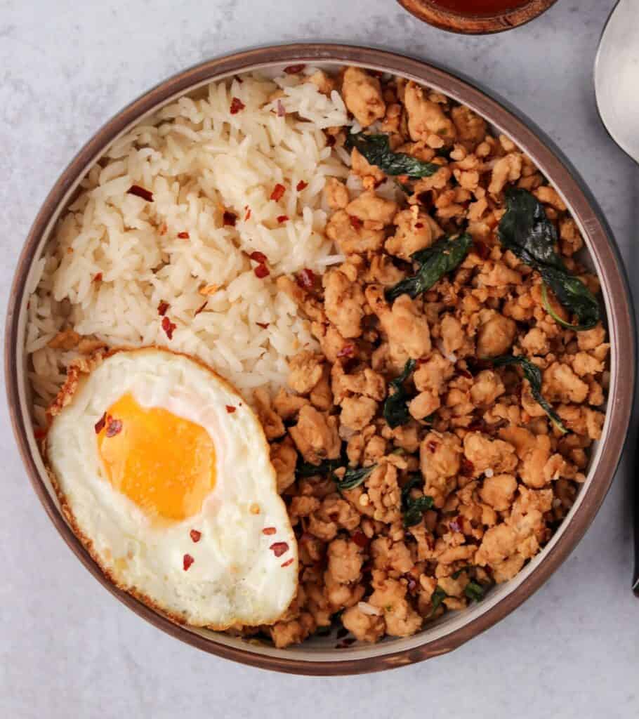 rice and a Thai style fried egg in a bowl with Thai basil chicken