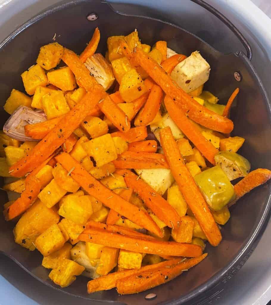 roasted butternut squash, carrots, apple, shallots, and garlic in an air fryer basket
