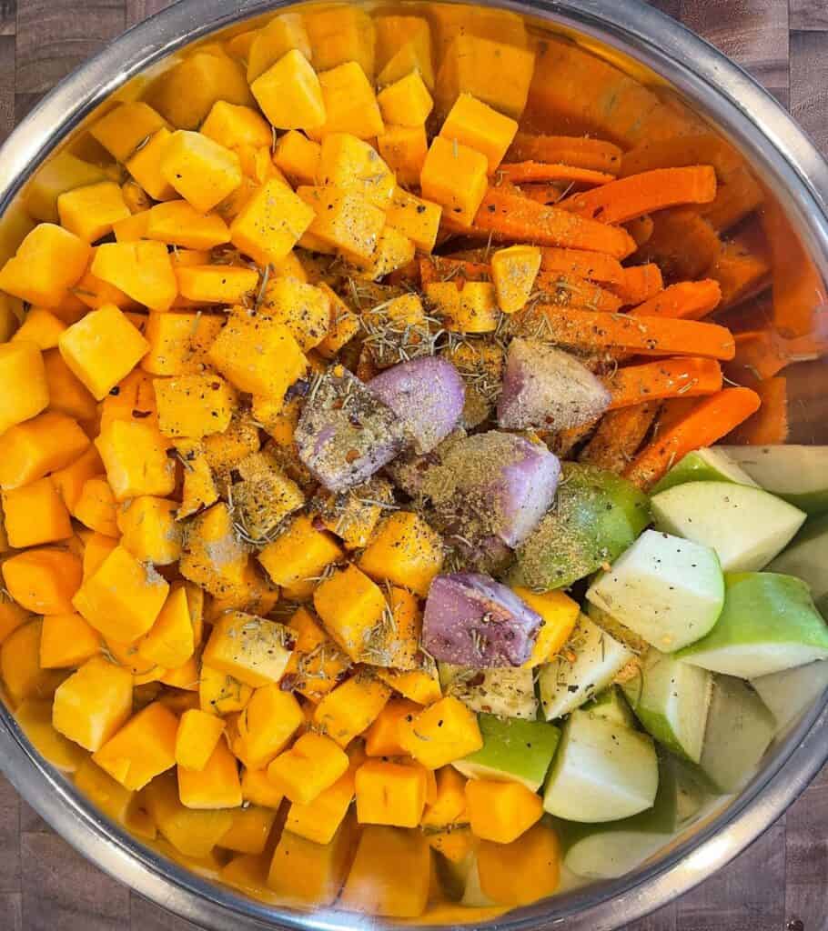 butternut squash, carrots, shallot, granny smith apple, olive oil, and seasoning in a mixing bowl