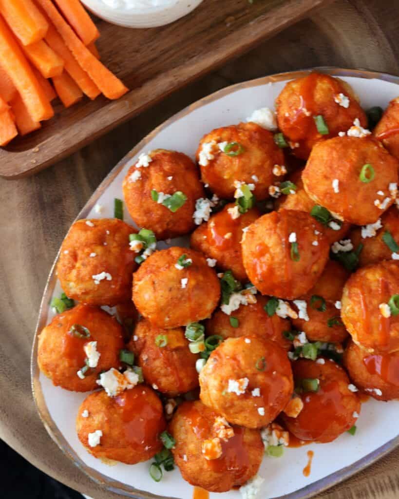 buffalo chicken meatballs on a plate with gorgonzola and green onion