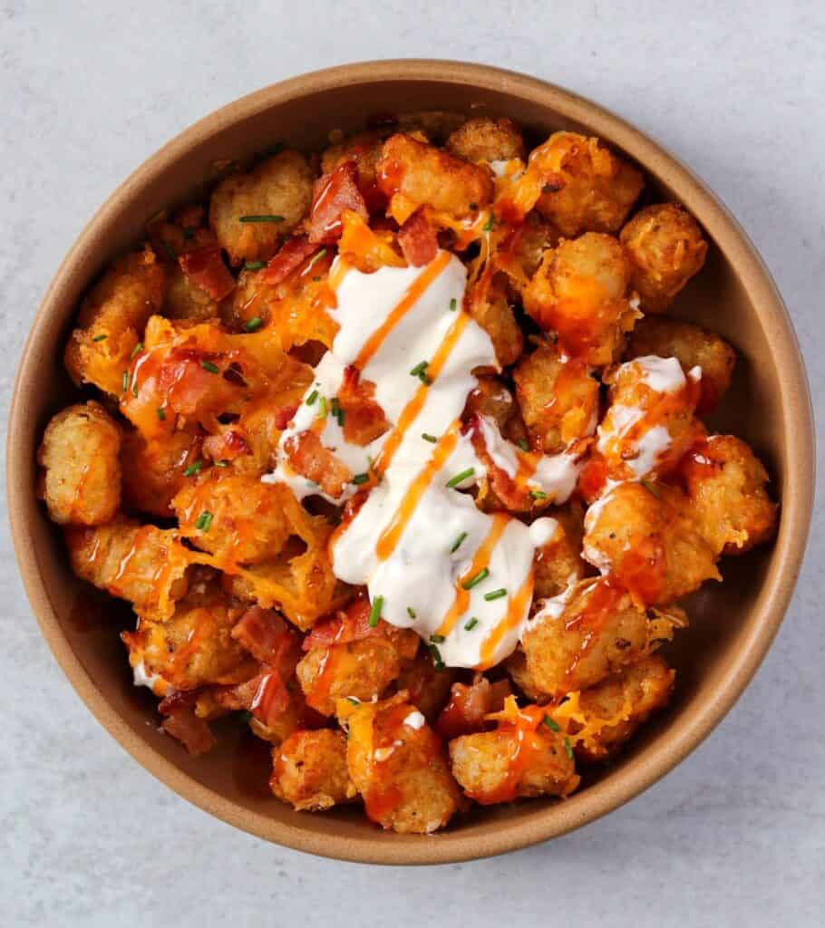 a brown bowl filled with loaded tater tots