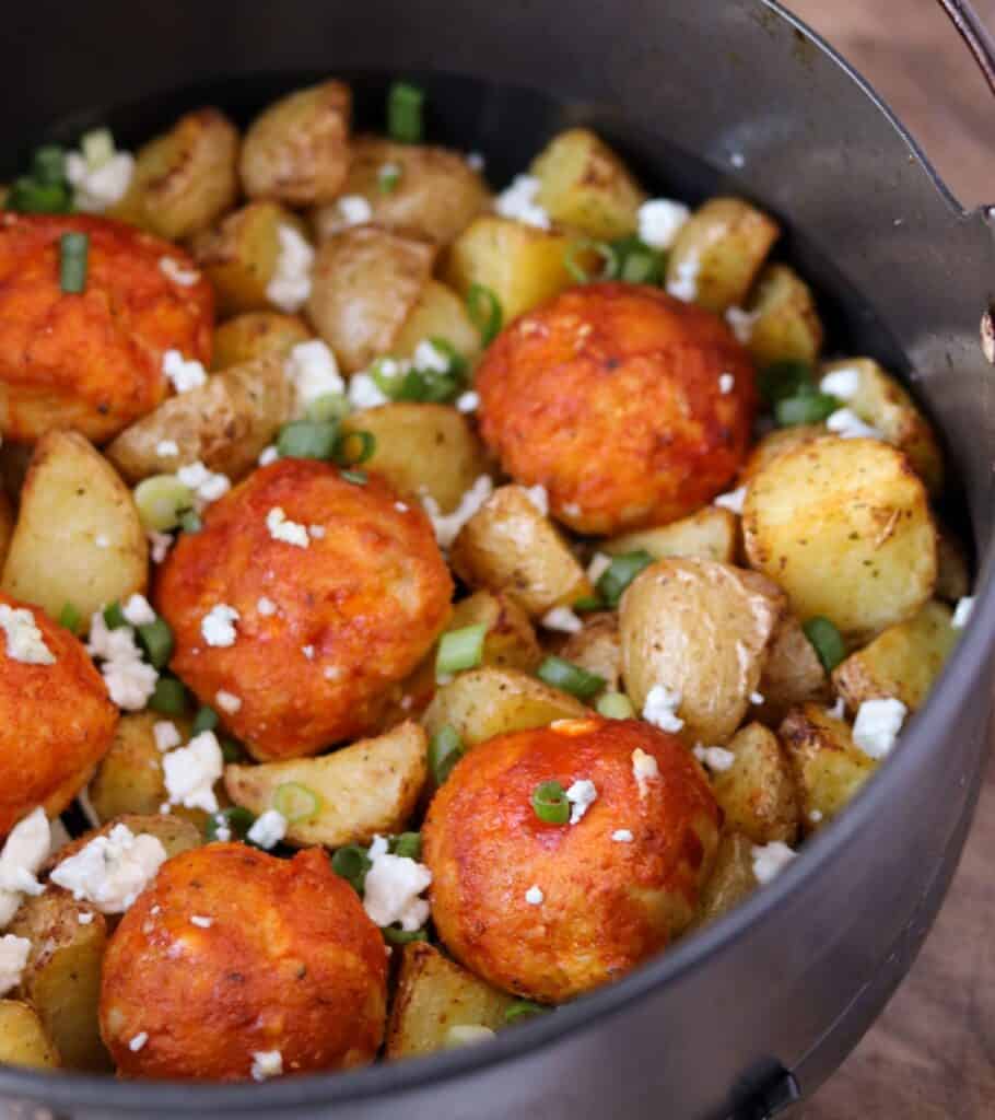smoked chicken meatballs in an air fryer basket with fried potatoes