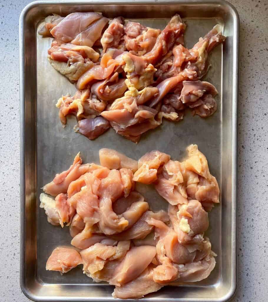 boneless skinless chicken breast and thighs on a sheet pan