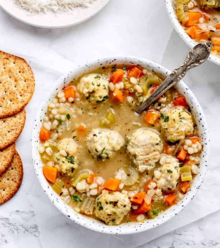 chicken meatball soup in a bowl with crackers on the side