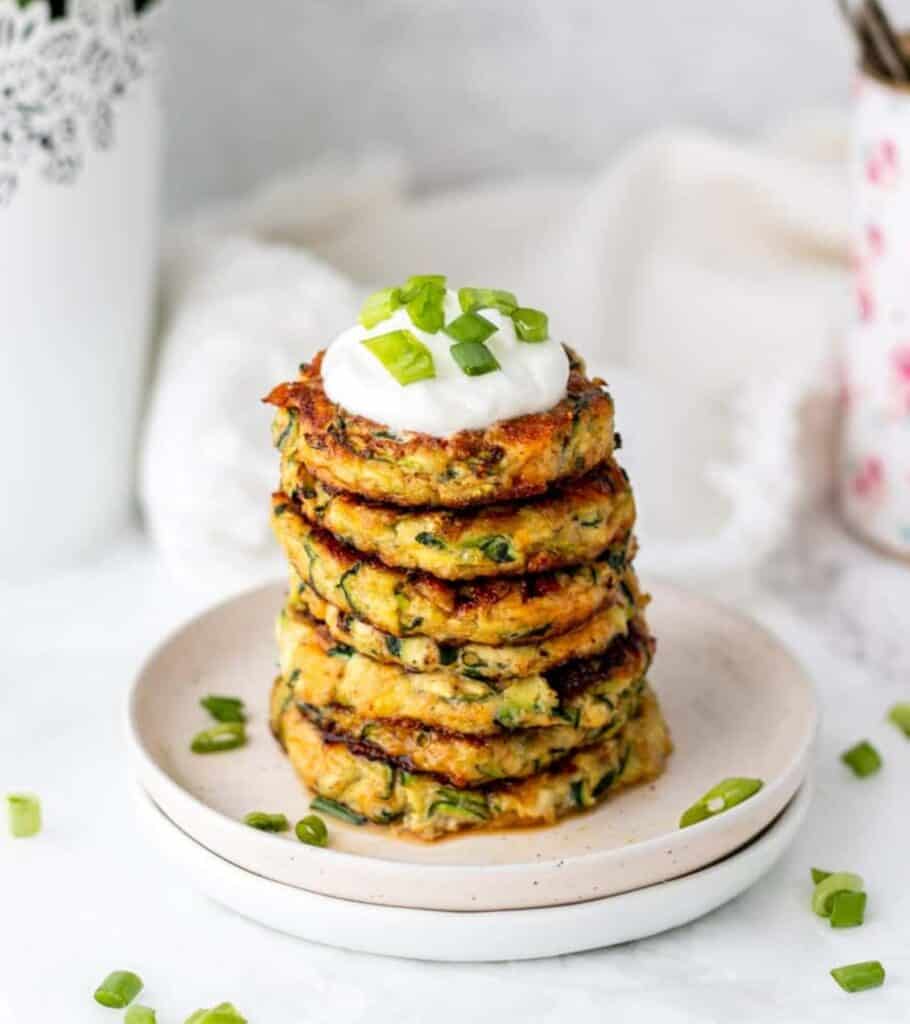 zucchini fritters on a plate with green onion