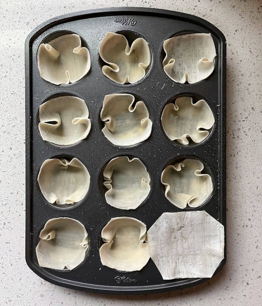 wonton wrappers in a greased muffin tin before baking