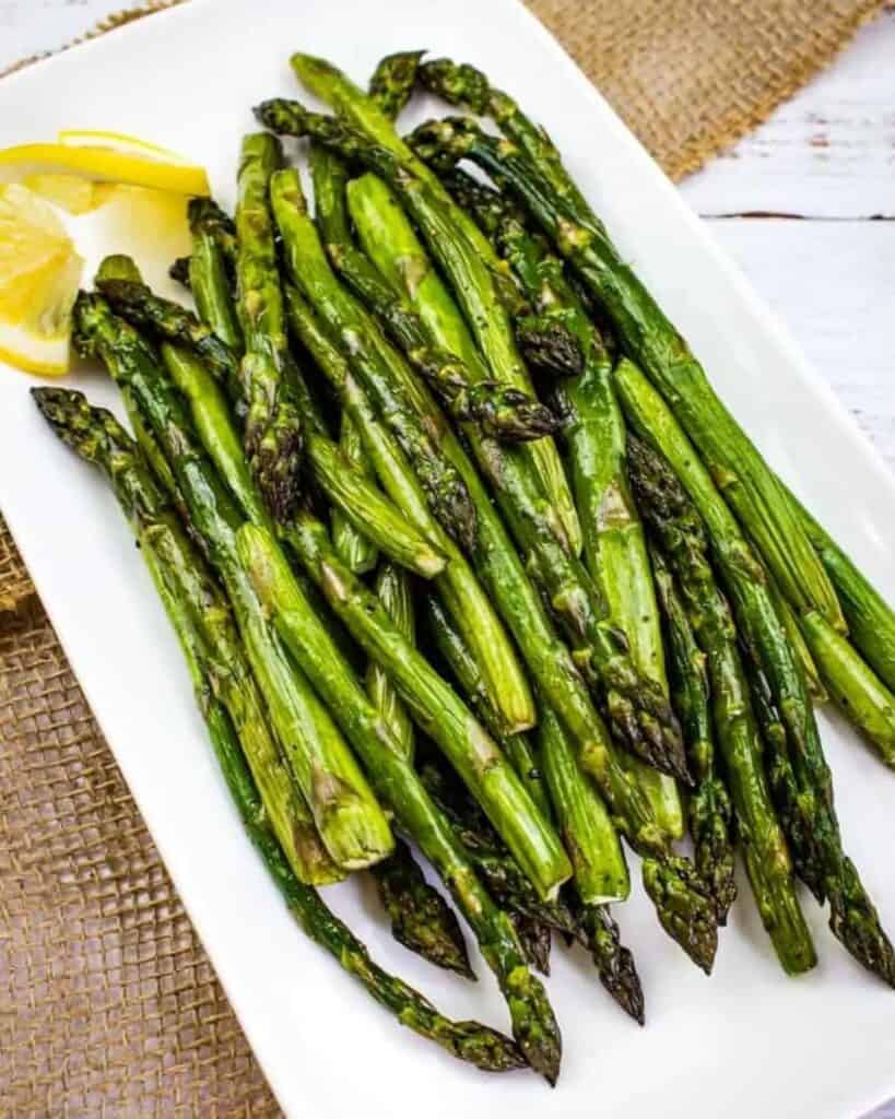 smoked asparagus on a plate with lemon