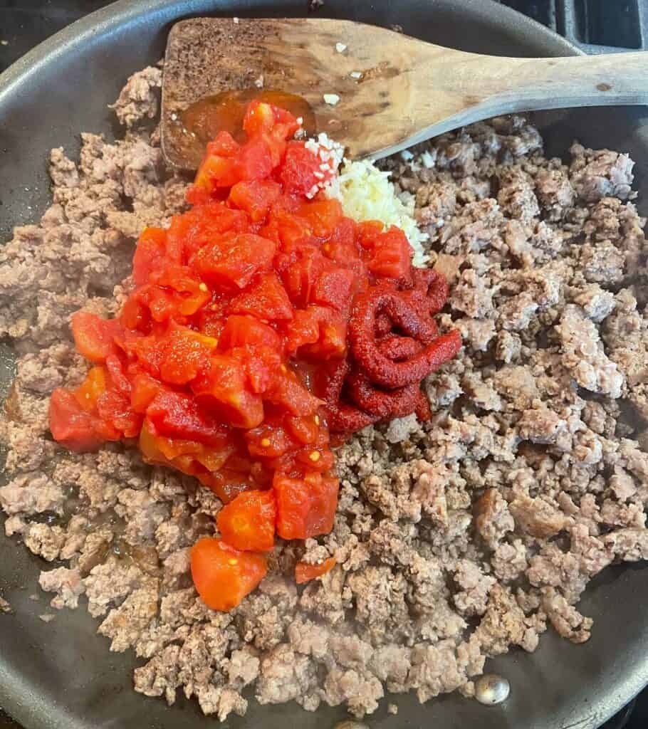 cooked ground beef and Italian sausage with tomato paste, diced tomatoes, and minced garlic