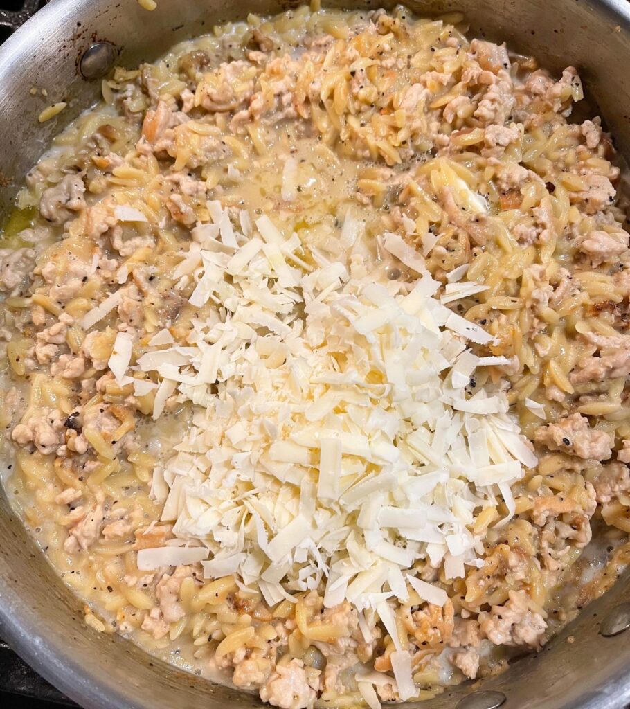 grated parmesan on top of cooked orzo and ground turkey mixed with butter and milk
