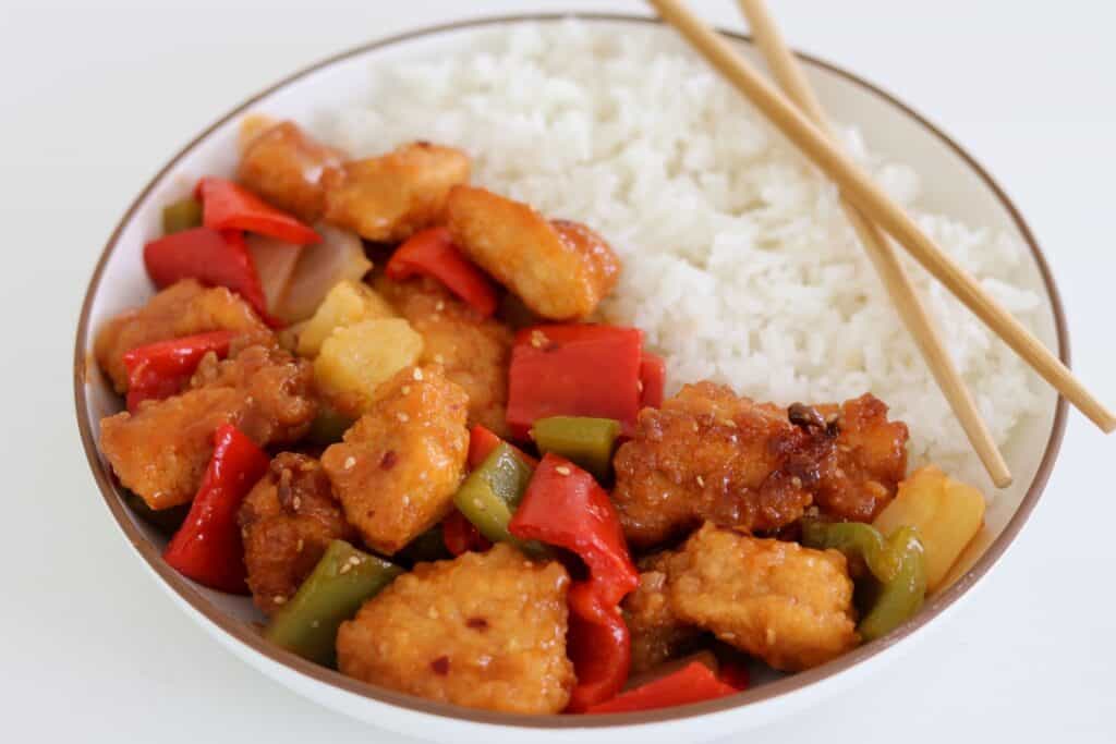 sweet and sour chicken in a bowl with rice
