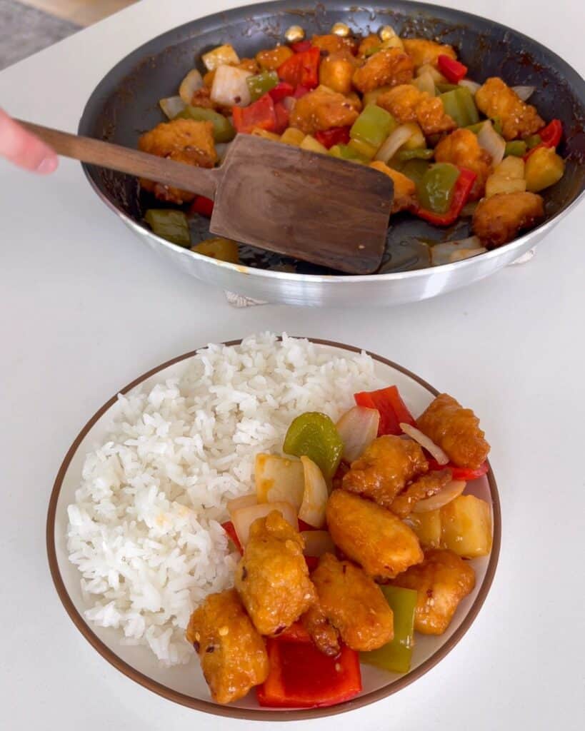 serving sweet and sour chicken from a skillet onto a plate with rice