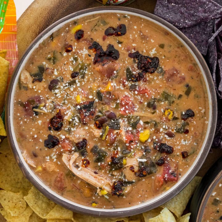 bowl of slow cooker chicken taco soup with tortilla chips, salsa macha, and cotija cheese