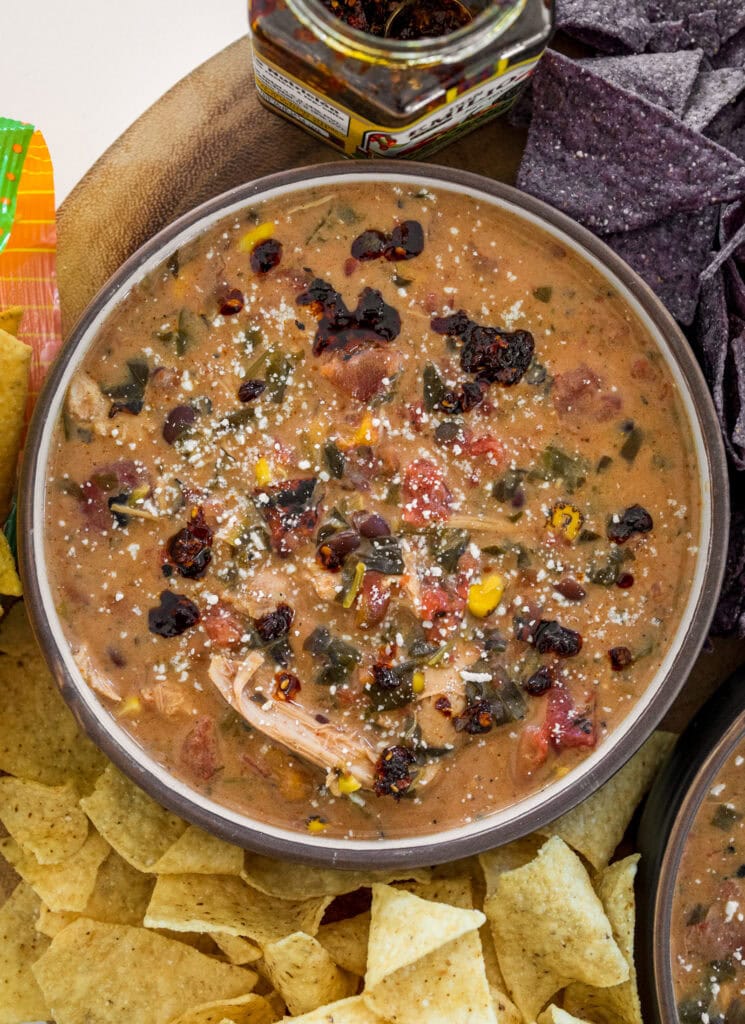 bowl of slow cooker chicken taco soup with tortilla chips, salsa macha, and cotija cheese