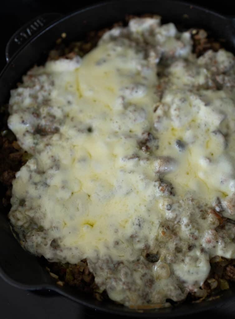 melted provolone cheese on top of ground beef and veggies