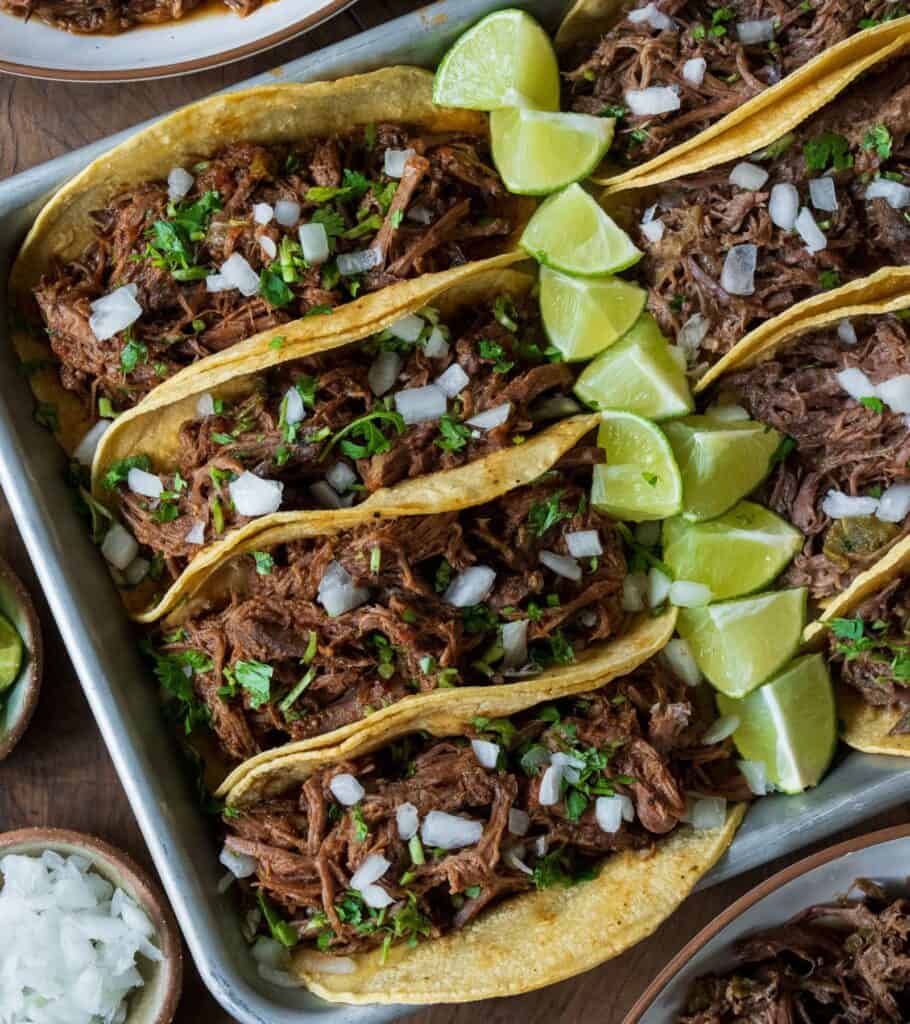 slow cooked beef tacos with lime, cilantro, and diced onion