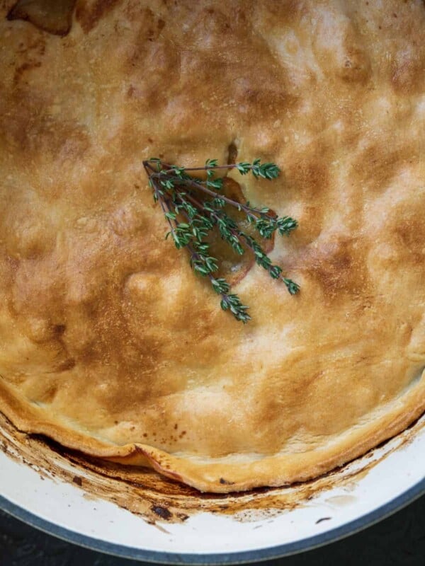 chicken pot pie in a Dutch oven with fresh thyme on top