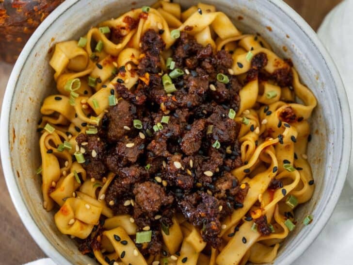 bowl of firecracker beef with noodles and chili oil