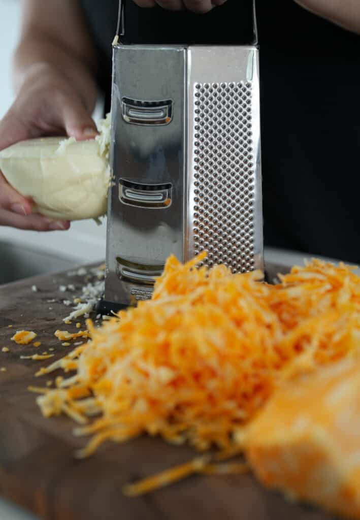 using a box grater to shred Colby jack and Oaxaca cheese