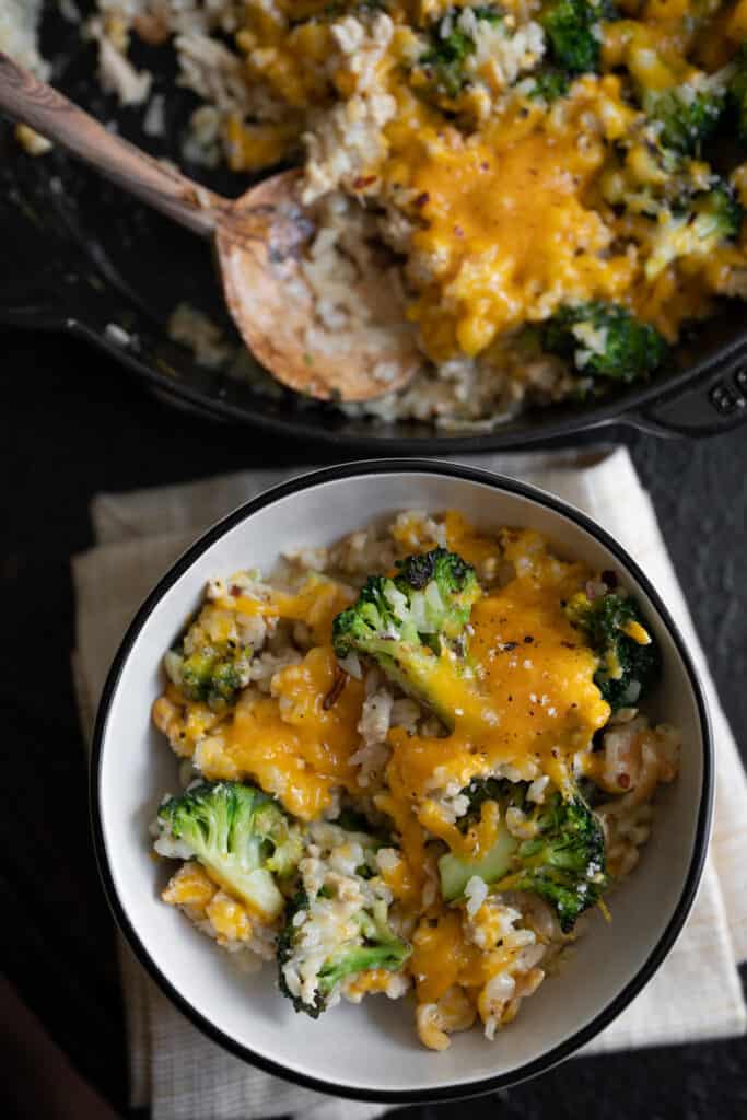 chicken broccoli and rice casserole in a bowl beside a skillet