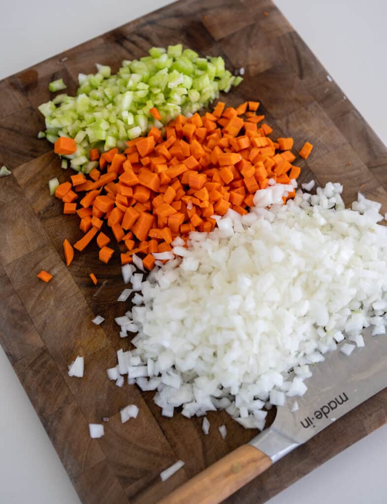 diced onions, carrots, and celery on a cutting board